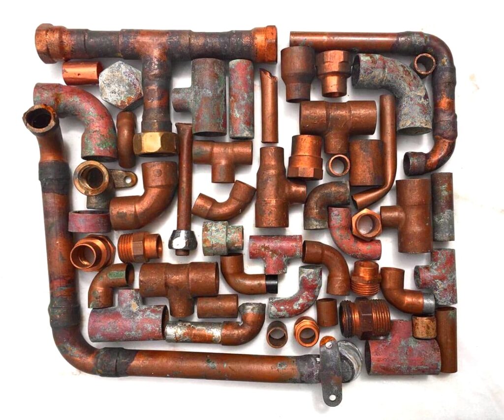 Skadat kopparrör med korrosion och gropfrätning orsakat av aggressivt vatten i VVS-system